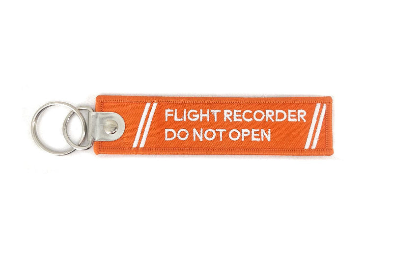 Porte-clés flamme en tissus orange avec broderie blanche "Flight ecorder do not open" sur le recto et le verso